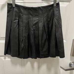 Black leather look skirts with pleats